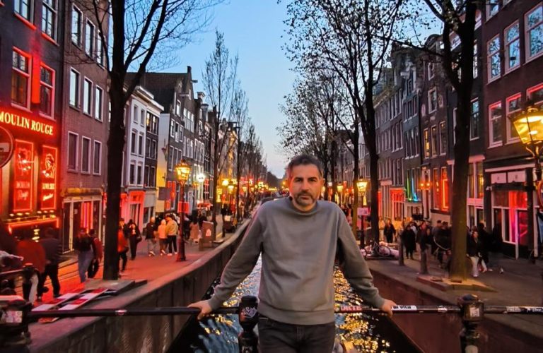 Akşam saatlerinde ışıklarla aydınlanan şehirde kanal kenarında yürüyüş.